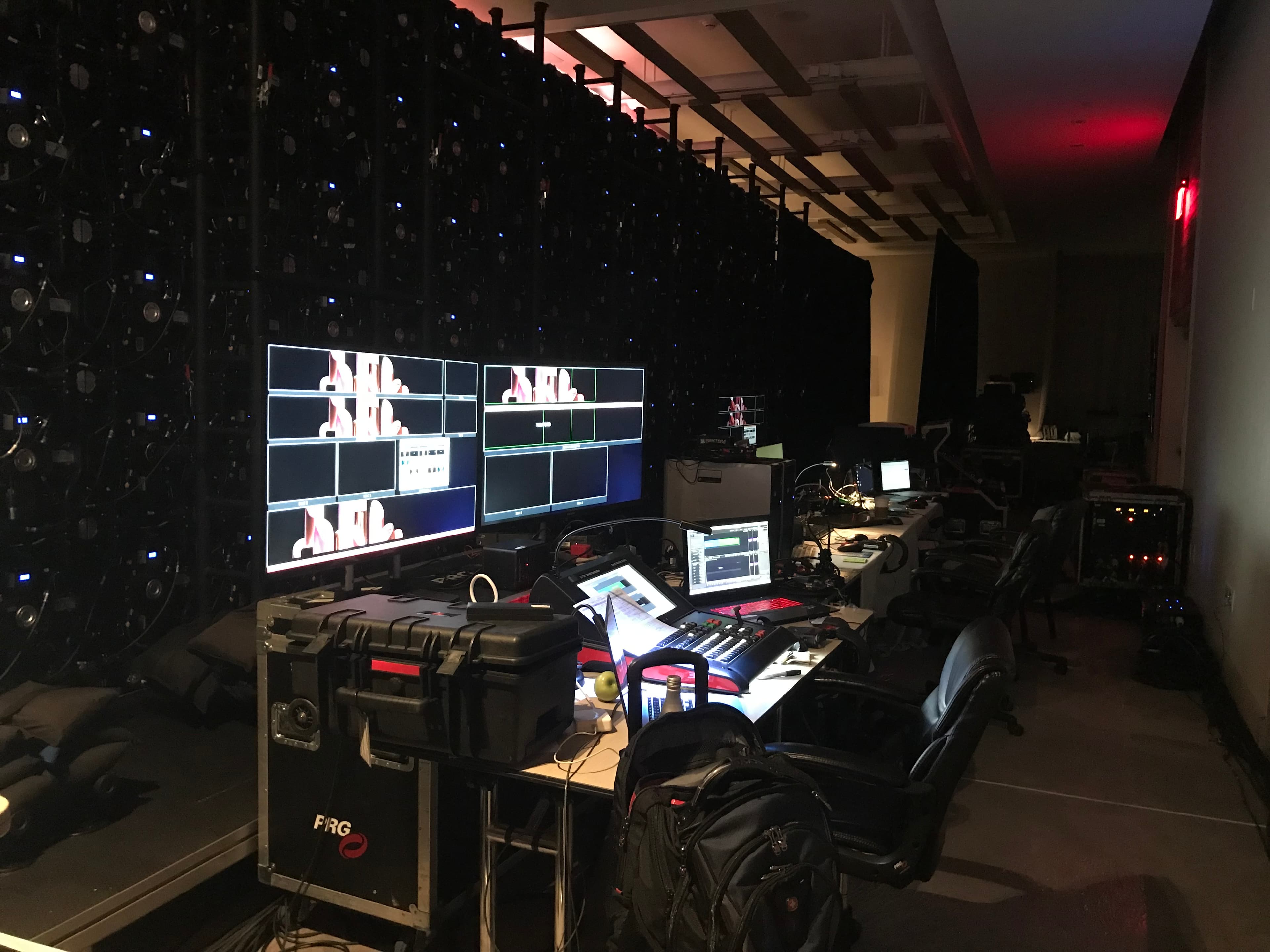 Professional video control room featuring multiple monitors, a control console, and large equipment racks.